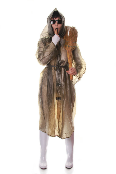 wirklich seltsame alte Dame spielt und posiert in transparentem Retro-Mantel und Gummistiefeln mit Besen auf weißem Hintergrund isoliert allein - Foto, Bild