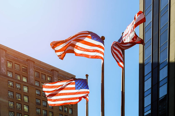 Flaga Amerykańska przeciw jasne niebo niebieski amerykańską flagę przed niebo i drapacze chmur - Zdjęcie, obraz