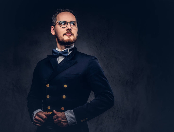 Portrait of a bearded male in glasses and antique suit on a dark - Photo, Image