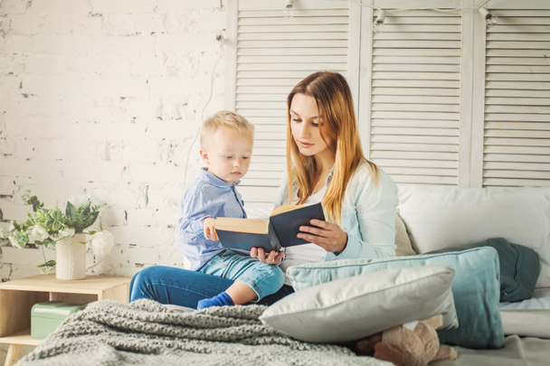 Αρκετά νέοι η μητέρα ανάγνωση ένα βιβλίο για τον γιο της. Μαμά και παιδί - Φωτογραφία, εικόνα