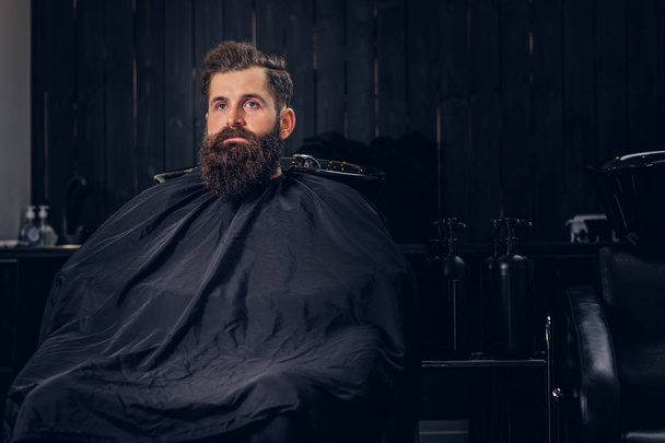 Handsome bearded man with before hair wash in a hairdressers salon. - Photo, Image