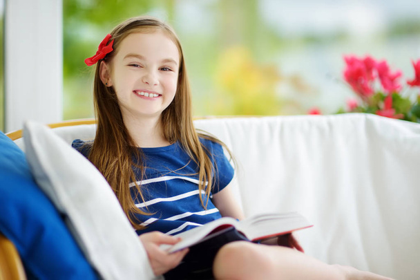 girl reading book in living room - Фото, зображення