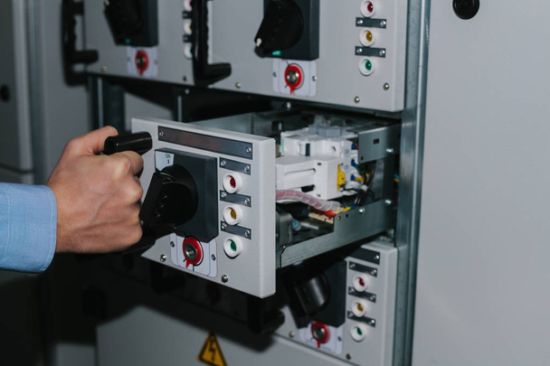 Electricista especialista comprobando equipos de gabinete de baja tensión
 - Foto, imagen