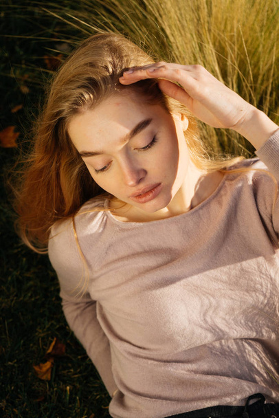 vonzó fiatal szőke nő pózol egy mező a nap - Fotó, kép