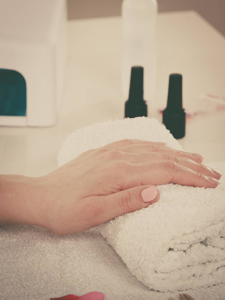 Woman hand on towel, next to manicure set - Foto, afbeelding