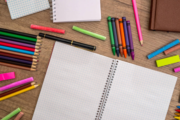 Blank notebook with pencils, chalk colour on wood table. - Φωτογραφία, εικόνα