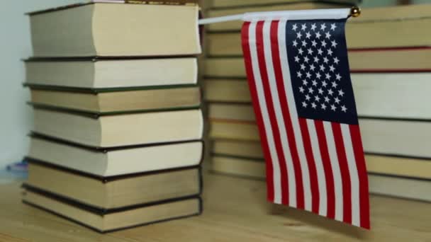 Bize bayrak ve kağıt kitap, bir kütüphane. Kitapların arka plan üzerinde Amerikan bayrağı. - Video, Çekim