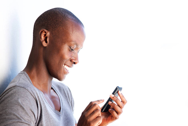 Side portrait of happy young black man using cellphone - Fotografie, Obrázek