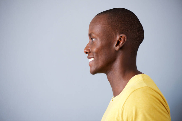 Retrato de perfil de hombre negro sonriendo sobre fondo gris
 - Foto, Imagen