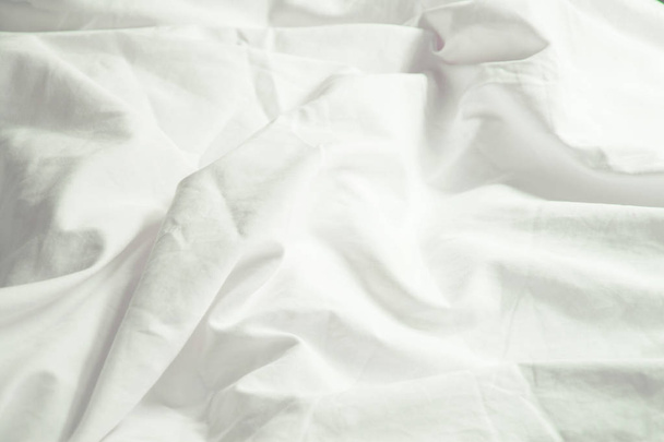 Białą poduszkę na łóżku i z zmarszczek niechlujny koc w sypialni, przed spaniem w długą noc zima. - Zdjęcie, obraz