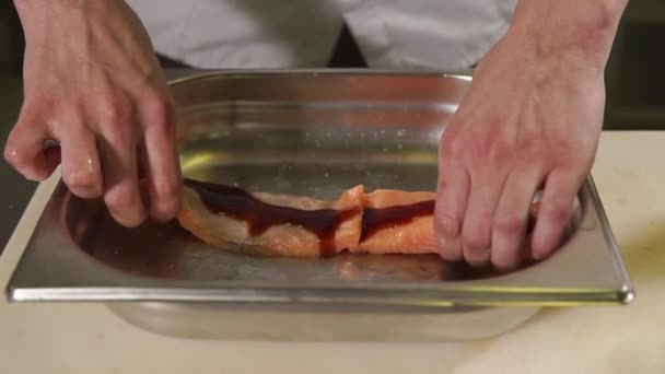 Detailní záběr záběr kuchaři ruce, muž je vaření kousek pstruha v restauraci - Záběry, video