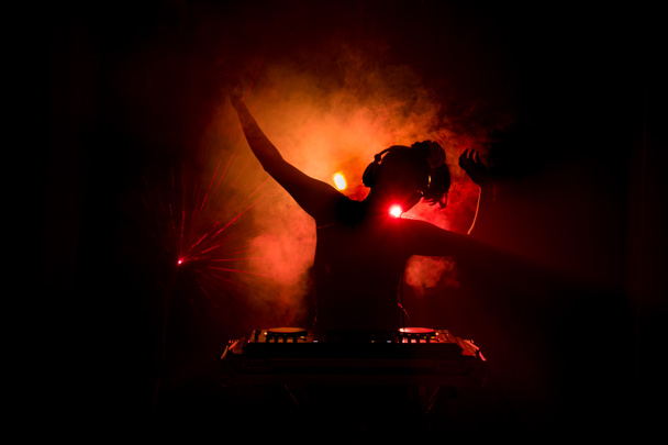 DJ Spinning keverő és karmoló, egy éjszakai klub, dj kezében csípés különböző pálya vezérlők, dj fedélzeten, strobe fények és köd, vagy Dj keveri a pályán, a nightclub-Party - Fotó, kép