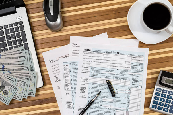 Steuerformular mit Kaffee, Laptop, Stift und Taschenrechner und Dollar - Foto, Bild