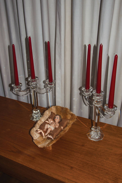 Table with candlesticks and doll representing the birth of Jesus Christ, indoors in Sao Paulo. The gigantic city, famous for its cultural and business vocation. Southeast Brazil. - Photo, Image