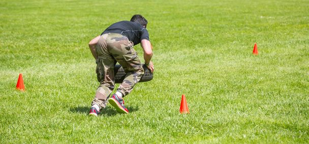Young coach demonstrating crossfit exercise outdoor - 写真・画像