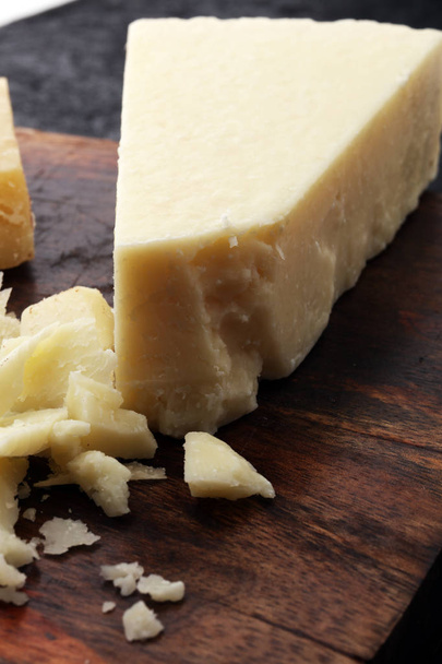Um queijo parmigiano reggiano parmesão autêntico envelhecido com queijos
 - Foto, Imagem