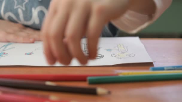 Little girl draws the pictures using color pencils - Imágenes, Vídeo