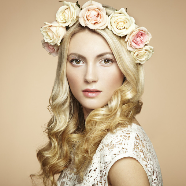 Portrait of a beautiful blonde woman with flowers in her hair - Φωτογραφία, εικόνα