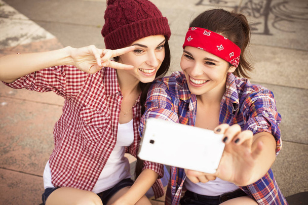 Dos amigas adolescentes morenas en traje hipster (jeans shor
 - Foto, Imagen