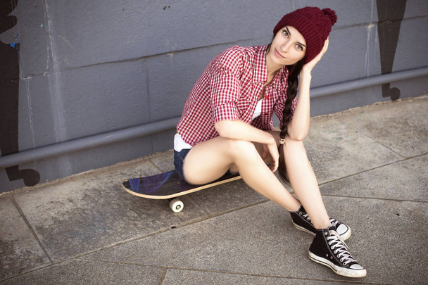 Menina adolescente morena em roupa hipster (calções de ganga, keds, pla
 - Foto, Imagem