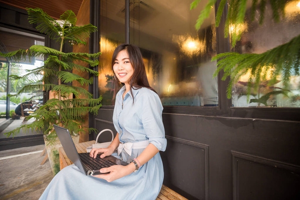 Les femmes d'affaires utilisent un ordinateur portable assis sur le banc dans un café, Communication d'affaires
 - Photo, image