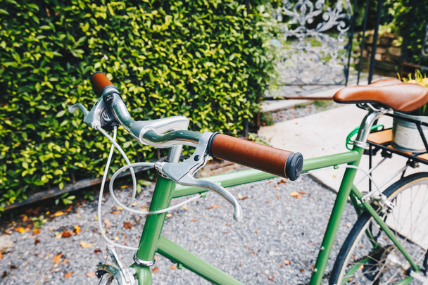 Old vintage bike parking in garden of cafe green background - Photo, Image