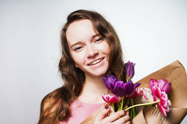 beautiful smiling girl holding a bouquet of fragrant flowers, celebrating the world women's day, March 8 - 写真・画像
