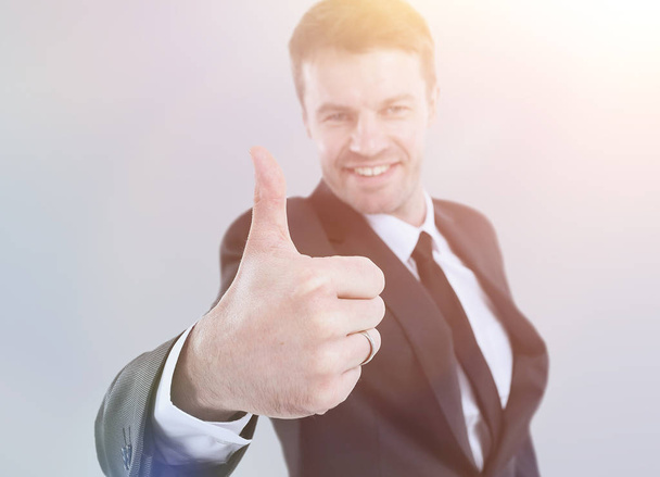 Handsome young business man showing thumb up on gray background - Photo, Image