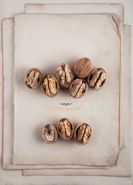 Beautifully presented walnuts on old book pages can be used as background - Photo, Image