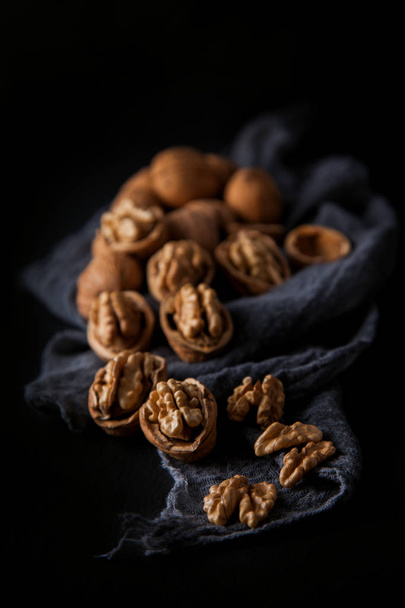 Beautifully presented walnuts on dark slate plate kitchen table with napkin can be used as background - Фото, зображення