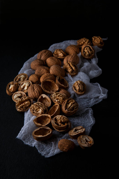 Beautifully presented walnuts on dark slate plate kitchen table with napkin can be used as background - Фото, зображення