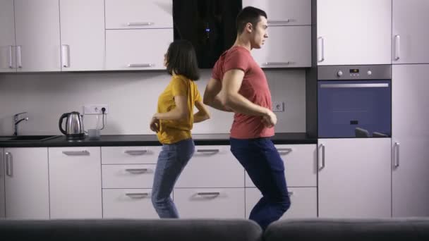 Jóvenes parejas creativas bailan movimientos en la cocina
 - Metraje, vídeo