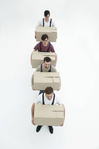 Jonge verhuizers holding dozen staan in een rij, geïsoleerd op wit  - Foto, afbeelding