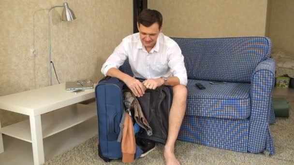 husband alcoholic sits on the couch gets out of a suitcase alcohol drink. a divorce - Záběry, video
