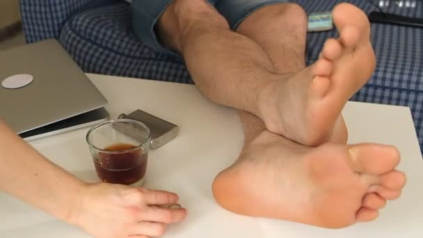 a woman and a man take off the wedding rings and put them on the table. on the table is alcohol, feet of men. close-up - Footage, Video