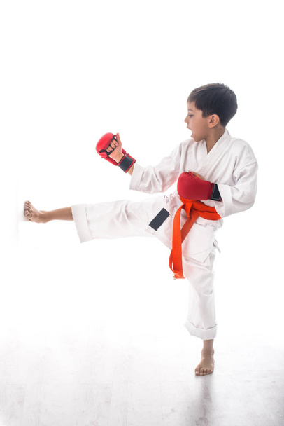 хлопчик карате в білому кімоно в помаранчевому дзвіночку і червоних рукавичках битви або потяги
 - Фото, зображення