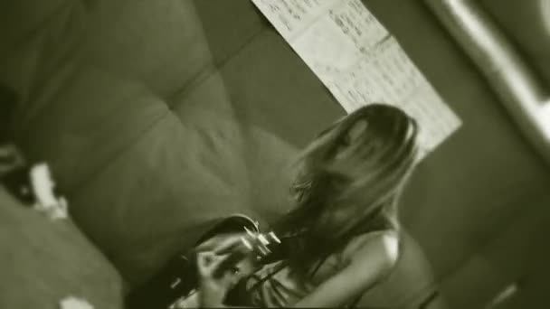 Rock and roll time. A girl with long hair is actively playing a guitar. Old movies. Hand held camera. - Πλάνα, βίντεο