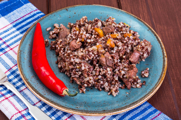 Garnish of red rice, garlic, vegetables, chicken meat - Photo, Image