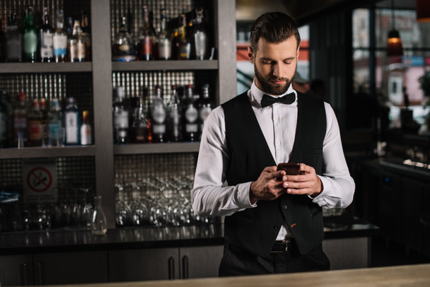 bello barista utilizzando smartphone al bancone del bar
 - Foto, immagini