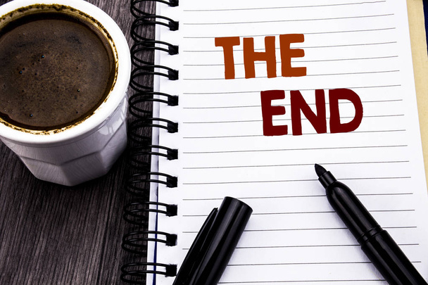 Writing text showing The End. Business concept for End Finish Close written on notebook book note paper on the wooden wood background. With coffee and black marker. - Photo, Image
