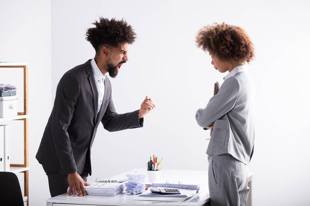 Angry Young Businessman Shouting At Female Executive In Office - Photo, image