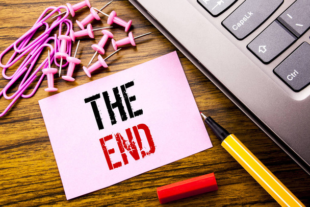 Handwritten text showing The End. Business concept for End Finish Close written on pink sticky note paper on the wooden background next to keyboard. With red pen. - Photo, Image