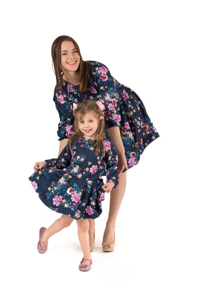 mother with the daughter in identical dresses  dance and smile - Fotografie, Obrázek