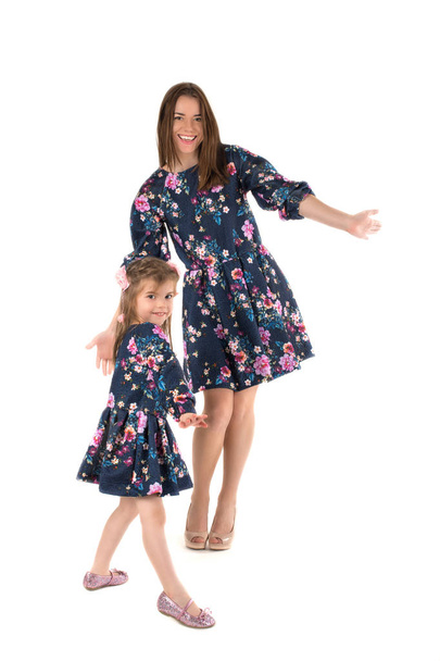 mother with the daughter in identical dresses  dance and smile - Foto, afbeelding