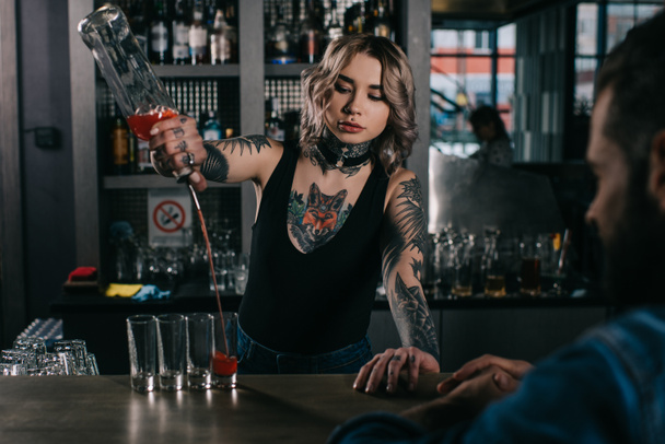 tatuato barista making shot drinks per uomo a bar
 - Foto, immagini