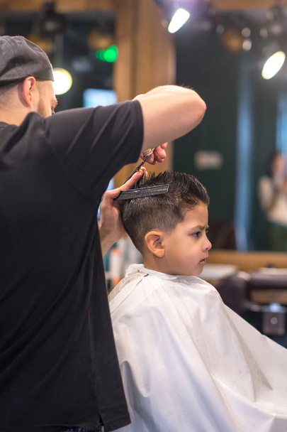 el muchacho es cortado en el salón de peluquería
 - Foto, imagen