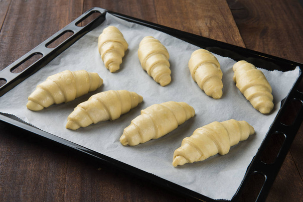 Raw croissants prepared for baking - Foto, afbeelding