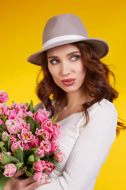 Весенняя девочка с цветами тюльпаны в руках на светлом фоне
 - Фото, изображение
