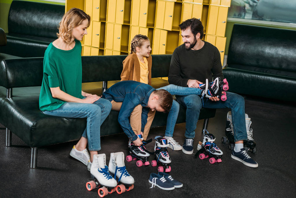 family wearing roller skates before skating in skate park - Фото, изображение