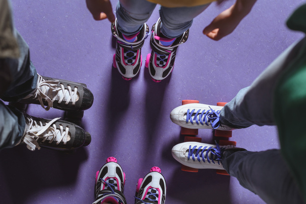 partial view of family in roller skates standing on roller rink - 写真・画像